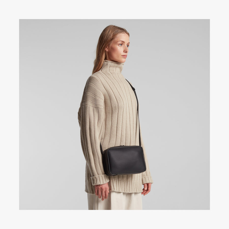 Carbon Black (Vegan Leather) | Angled view of Metro Crossbody in Carbon Black