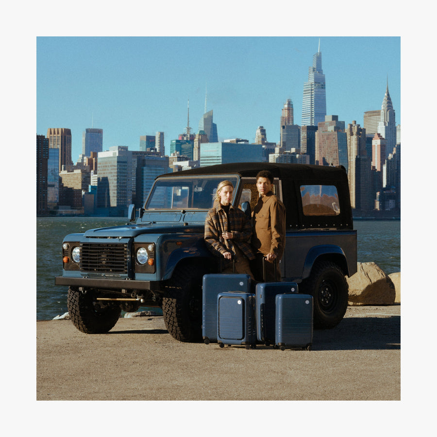 Set of Four / Arles Blue | Couple with Arles Blue suitcases by a car in New York City