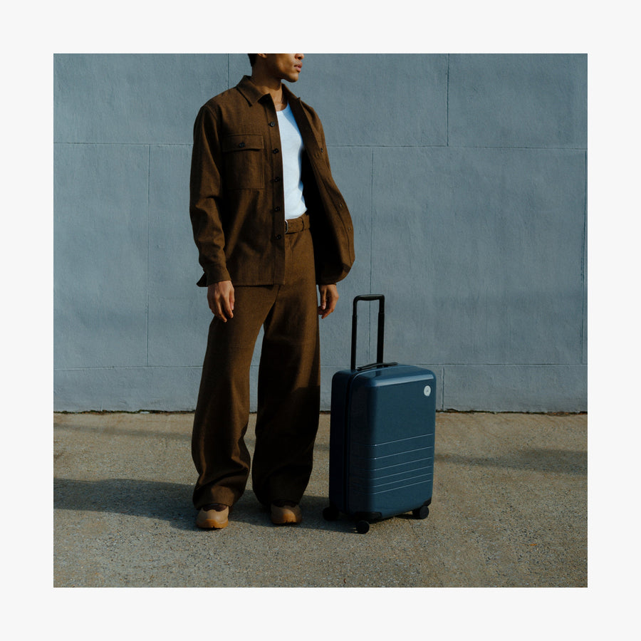Set of Four / Arles Blue | Man standing next to a Carry-On in Arles Blue