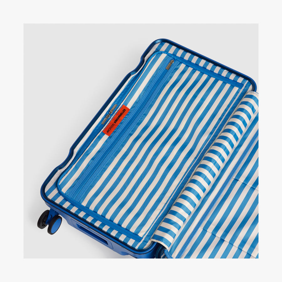 Coastal Blue | Interior view of a Hybrid suitcase in Coastal Blue featuring the Poplin Stripe Coastal Blue zipped compartment
