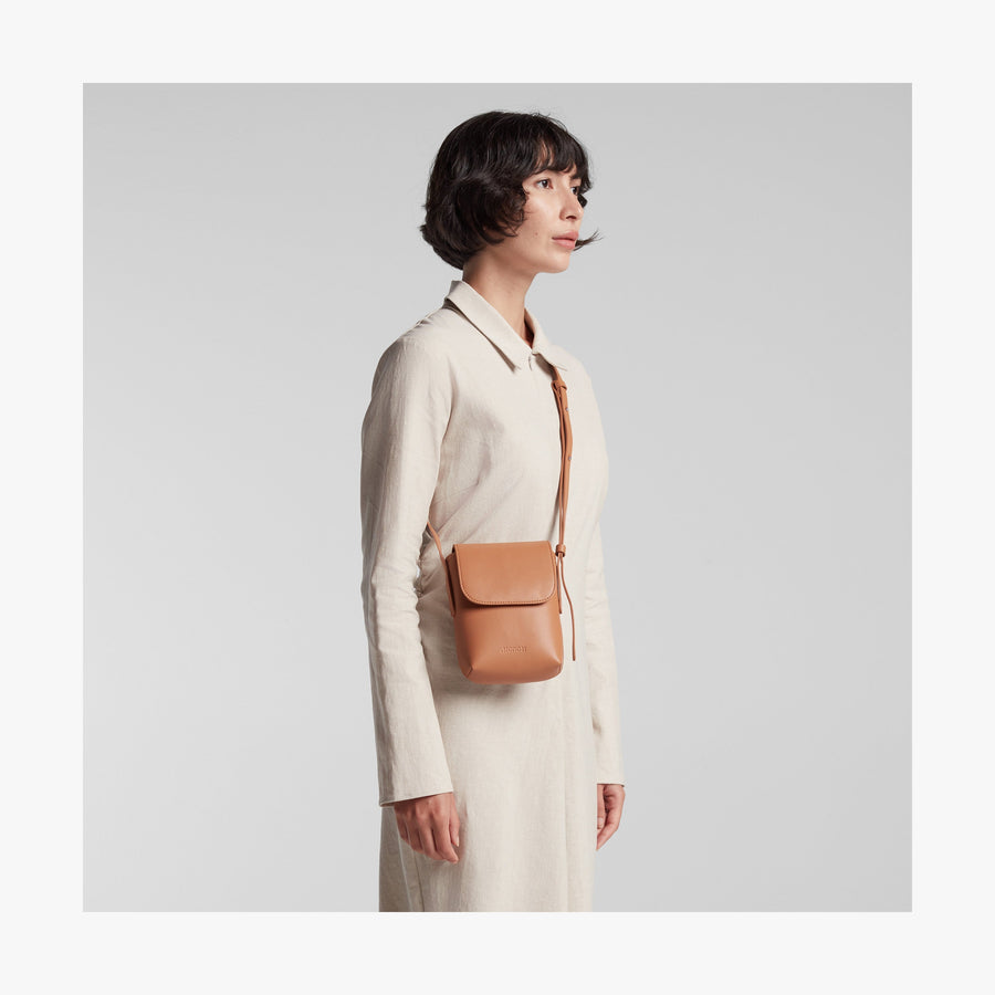 Saddle Tan (Vegan Leather) | Angled view of Metro Mini Crossbody in Saddle Tan