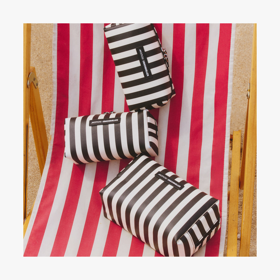 Large / Poplin Stripe Black | Three Metro Toiletry Cases in Poplin Stripe Black displayed on a red and white striped beach chair